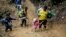 Migrantes con niños atraviesan la selva del Darién rumbo a Panamá en su ruta hacia Estados Unidos, el 15 de octubre de 2022. (AP Foto/Fernando Vergara, Archivo).