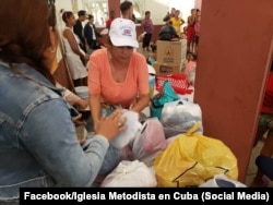 Miembros de la Iglesia Metodista entregan alimentos y otros productos de primera necesidad a evacuados por el huracán en el oriente de la isla.