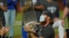 El tercera base de los Dodgers de Los Ángeles, Justin Turner, celebra con el trofeo luego de derrotar 3-1 a los Rays de Tampa Bay para ganar la Serie Mundial de béisbol.
