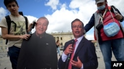 Votantes sostienen carteles con las imágenes de los candidatos presidenciales Gustavo Petro y Rodolfo Hernández. (Raul ARBOLEDA/AFP)