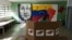 Al fondo imagen de Hugo Chávez, mientras un hombre emite su voto durante las elecciones regionales en un colegio electoral en Caracas, Venezuela, el domingo 21 de noviembre de 2021.