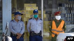 Policías cuidan las colas mientras los cubanos compran en dólares.