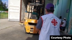 Funcionarios de Cáritas Cuba descargan uno de los cuatro contenedores con donaciones de material médico enviado por Catholic Charities de la Arquidiócesis de Miami a la Isla.