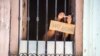 FOTO ARCHIVO. Un cubana anuncia con un cartel la venta de bocaditos desde su ventana. (AP Photo/Desmond Boylan)