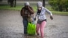 Cubanas tratan de cruzar una calle inundada por la lluvia.