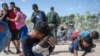 Una familia de inmigrantes después de romper una barricada de alambre de púas hacia los Estados Unidos, después de horas de espera en el Río Grande, en Eagle Pass, Texas, el 25 de septiembre de 2023. ANDREW CABALLERO-REYNOLDS / AFP.