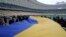 Una bandera ucraniana de 200 metros se despliega en el Estadio Olímpico de Kiev, Ucrania, el 16 de febrero de 2022. (AP Foto/Efrem Lukatsky)
