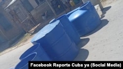 Tanques plásticos cortan una calle como protesta por falta de agua, en Isabela de Sagua, Villa Clara