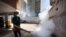 Un empleado de la Alcaldía de Chacao, en Caracas, fumiga un estacionamiento como medida preventiva contra el Zika. 