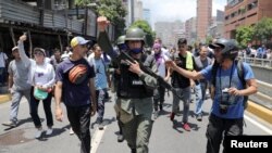 Un miembro de la Guardia Nacional Bolivariana se une a los manifestantes de la oposición durante las protestas en Caracas.